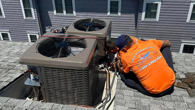 Comfort Pro technicians brazing two rooftop condensers above a Cape May County shore home