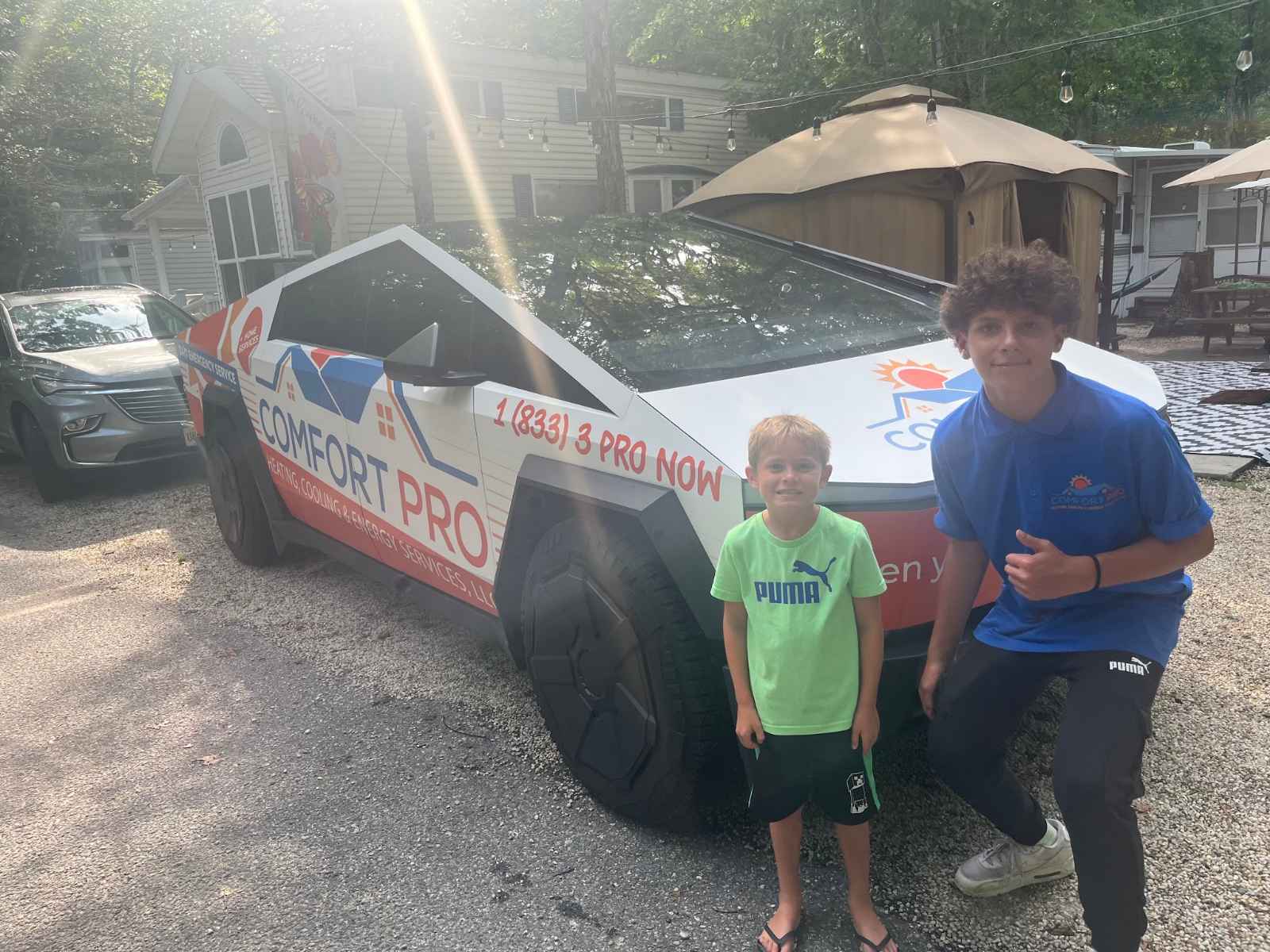 A young customer with a Comfort Pro team member beside the wrapped Cybertruck